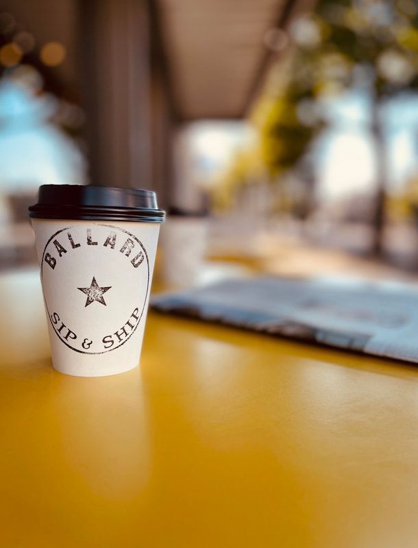 Coffee cup on a yellow table with a blurred street background.