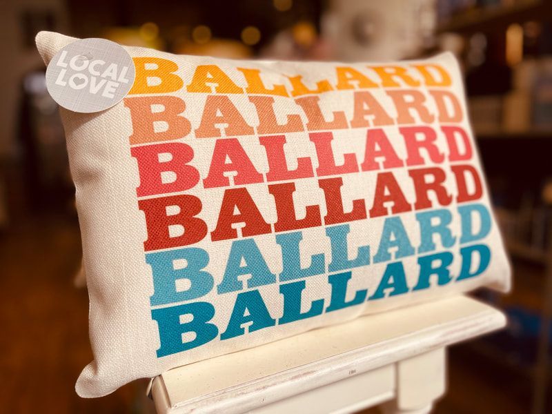 Ballard pillow with stacked colorful text on a white chair