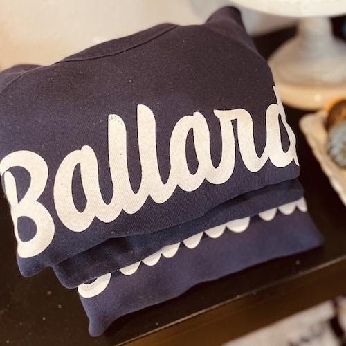 Folded navy shirt with the white word “Ballard” on a table