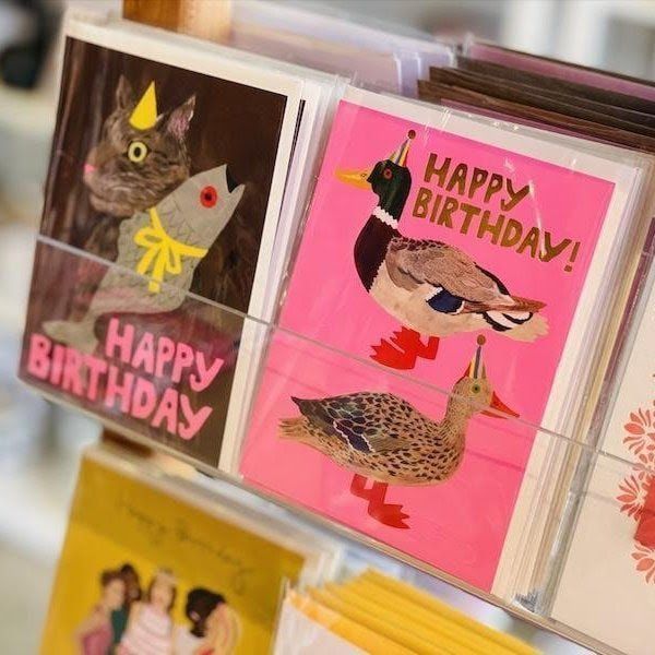 Colorful handmade birthday cards with cartoon animals and “Happy Birthday” text on display.