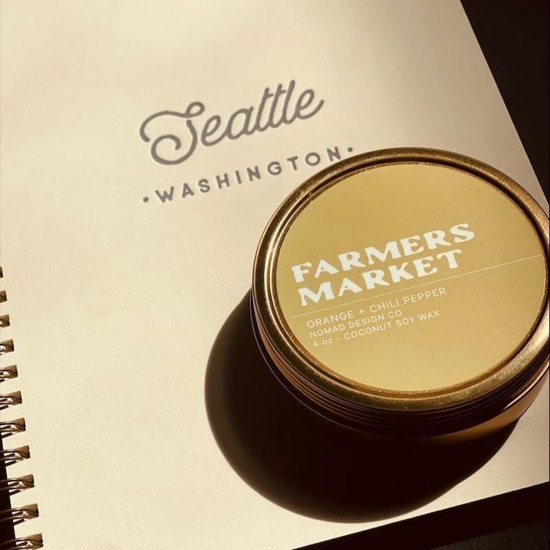 Seattle Washington notebook with a Farmers Market tin on top, lit by warm sunlight