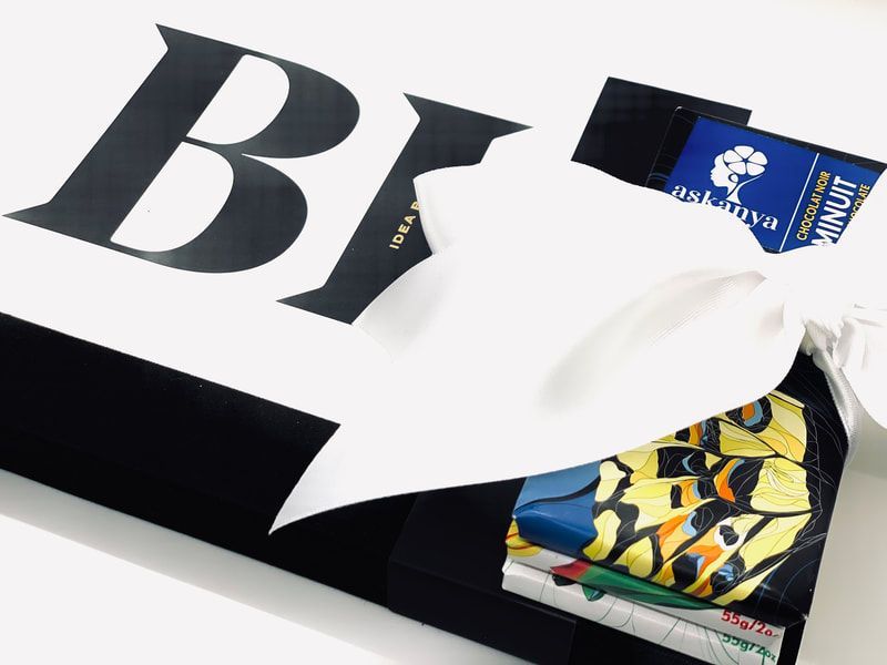 Black and white packaging with a blue label and folded colorful fabric peeking out