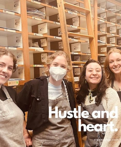 Four smiling people in an archive room with stacked boxes; text reads “Hustle and heart.”