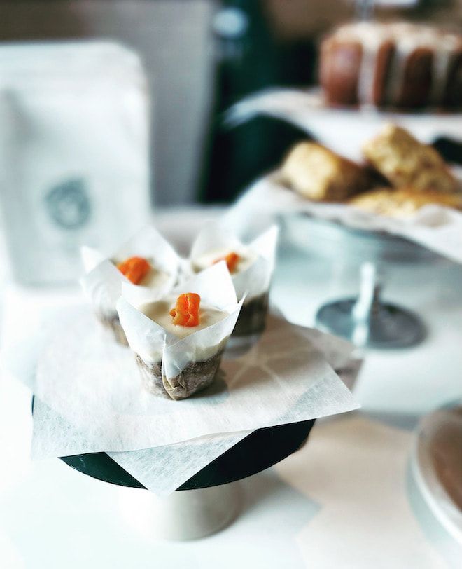 White dessert cups with orange garnish on a table at a café buffet
