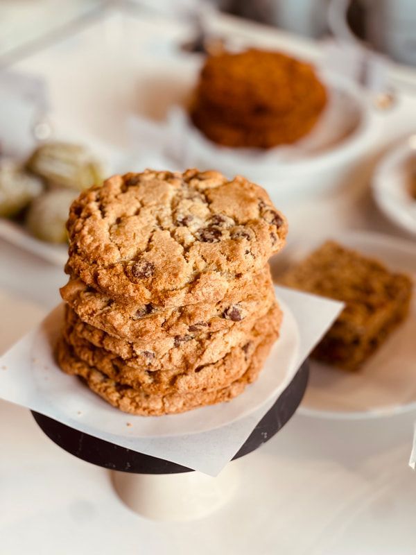 Stack of oatmeal cookies on a pedestal, with more cookies blurred in the background.