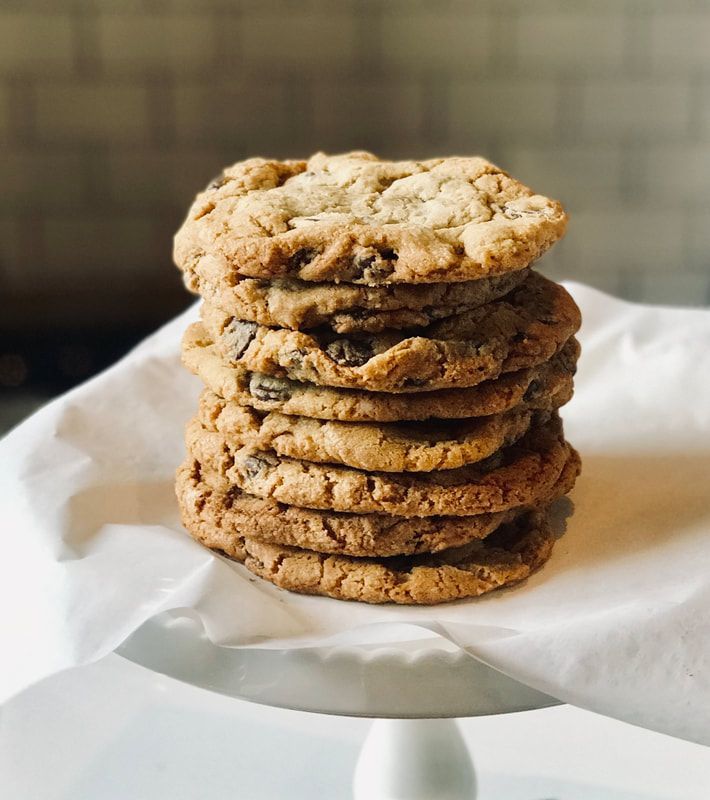 Stack of oatmeal cookies on a white plate lined with parchment paper