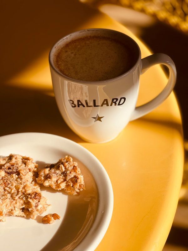 Coffee mug and granola bar on a yellow table in warm sunlight