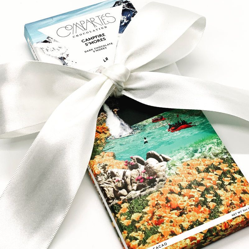 Gift box tied with white ribbon and tag, showing a tropical coral reef print on the package.