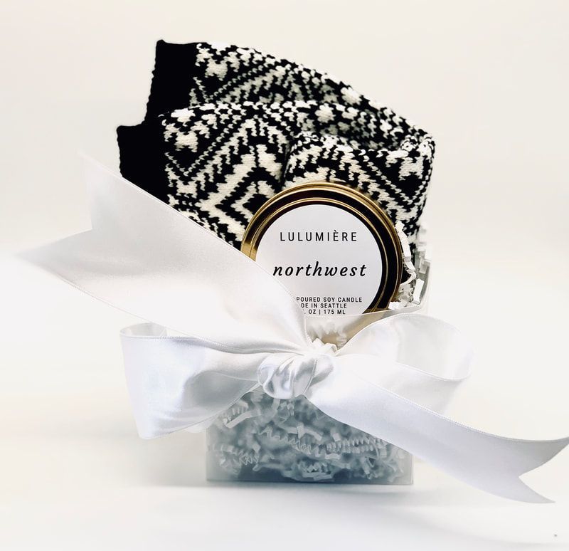 Black-and-white patterned gift pouch with a white bow and round label on a white background