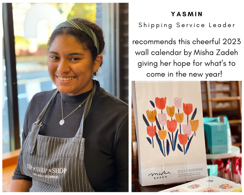 Woman in apron smiling beside a 2023 wall calendar with colorful tulips and a hopeful message.