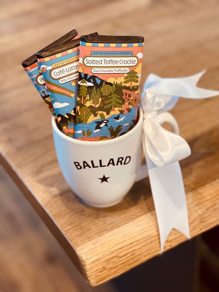 Ballard mug holding colorful tea packets with white ribbon on a wooden table