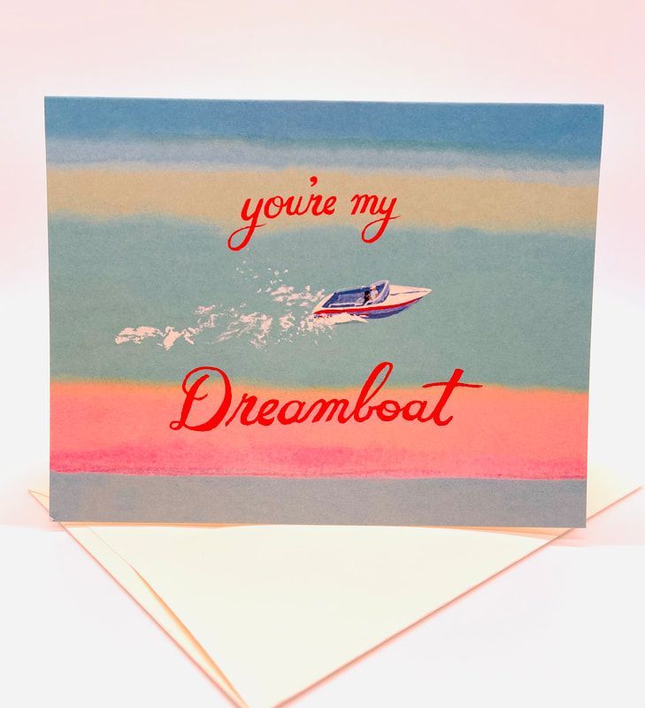 Greeting card with a small boat on pastel blue and pink stripes reading “you’re my Dreamboat”