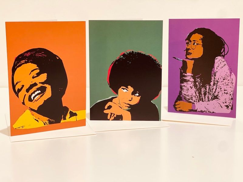Three pop-art portrait prints with bold colors: orange, green, and purple backgrounds.