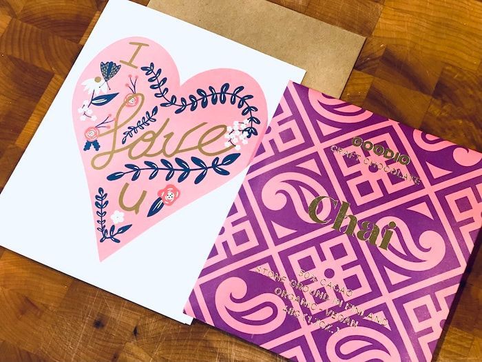Two handmade Valentine cards: pink heart with “I love u” and a magenta patterned card on a wooden table