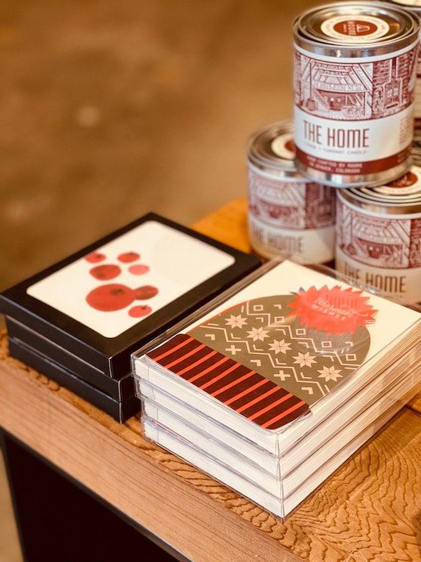 Stacked cat-themed notebooks and canned drinks on a wooden table