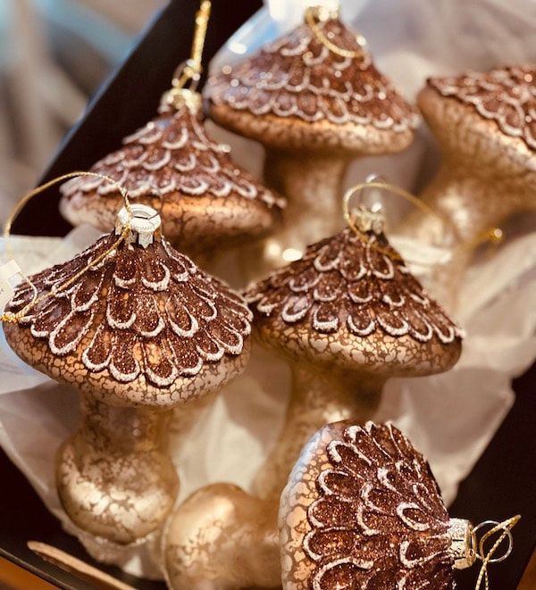 Brown and gold mushroom ornaments clustered on a soft fabric background