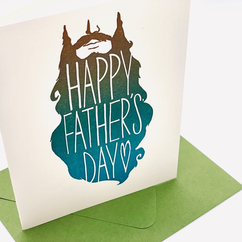Father’s Day greeting card with “Happy Father’s Day” text in blue and brown on a green envelope