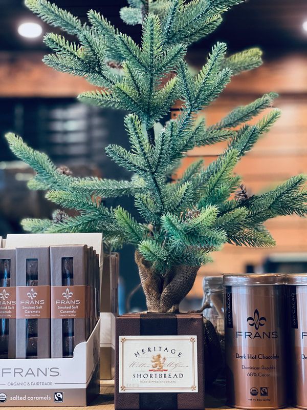Small potted evergreen with decorative bath products on a shelf indoors