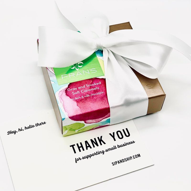Thank you gift box with white bow and pink-green label on a white background