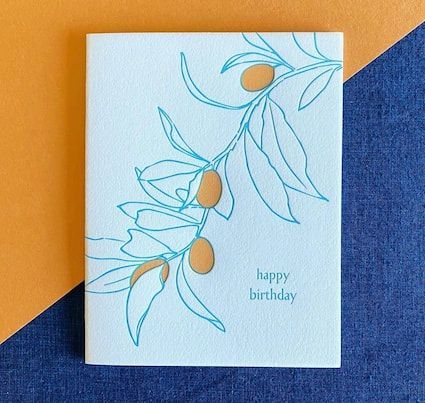 Minimal birthday card with blue floral line art and orange accents on a white background