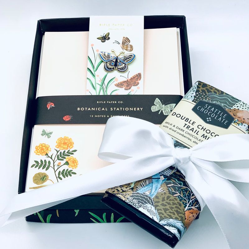 Stationery gift set in a navy box with floral cards, a butterfly note, and a white ribbon bow.