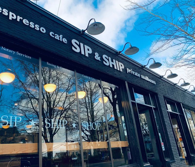 Exterior of SIP & SHIP espresso cafe with large windows and blue sky reflections