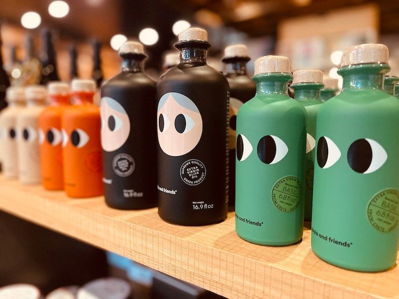 Colorful cartoon-faced bottles lined up on a shelf in a store or cafe.