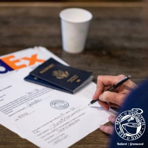 Person signing a form beside a passport and coffee cup on a desk