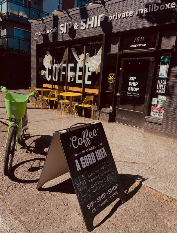 Sidewalk cafe storefront with “SIP SHIP Coffee” sign, yellow chairs, and a black sandwich board in front.