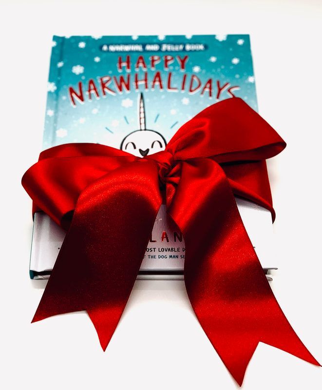 Gift wrapped in a red bow with a “Happy Narwhalidays” card on top.
