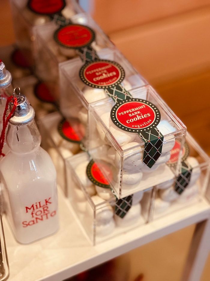 Gift bottles with red labels and a small milk bottle on a tray, likely a party favor display.