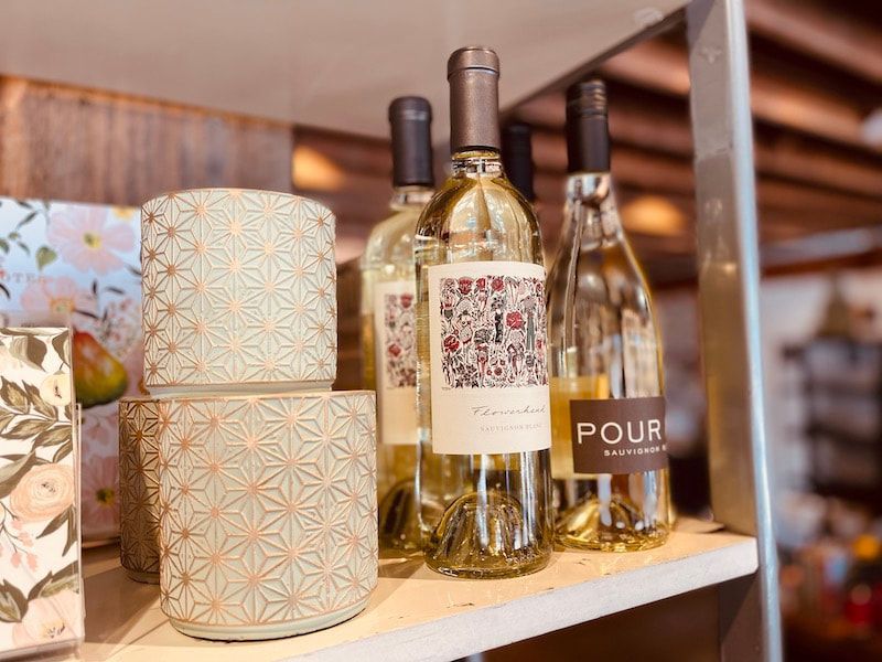 Wine bottles and decorative gift boxes on a store shelf