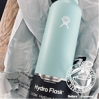 Mint green Hydro Flask bottle on wrinkled packaging paper.