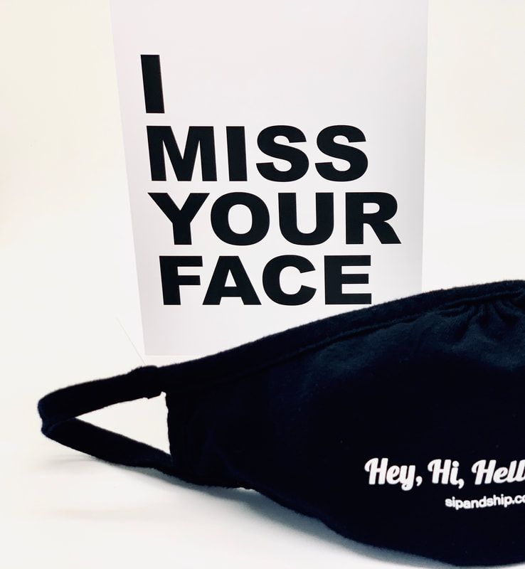 Black face mask with white text reading “Hey, Hi, Hello” beside a sign saying “I MISS YOUR FACE”