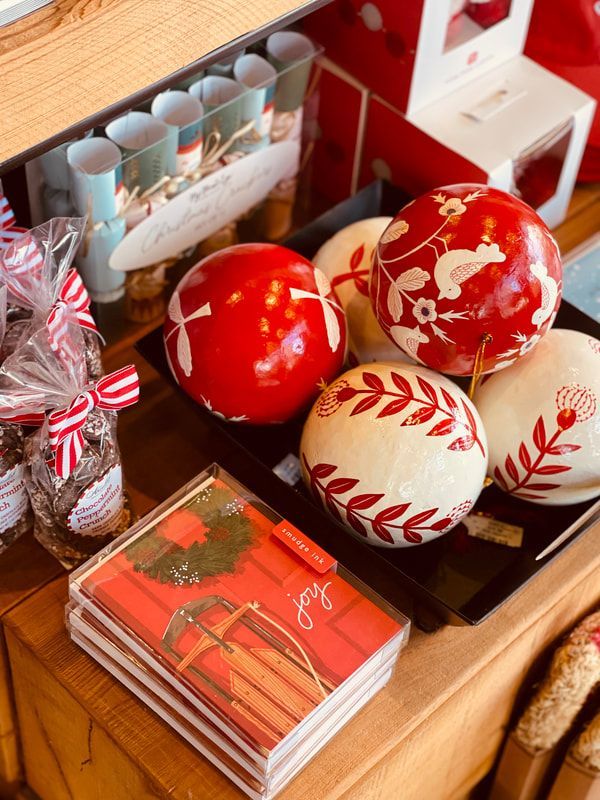 Red and white painted Christmas ornaments and cards arranged on a tray