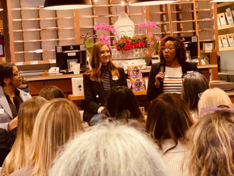 Panel discussion in a bookstore, with two speakers seated before an audience and shelves in the background
