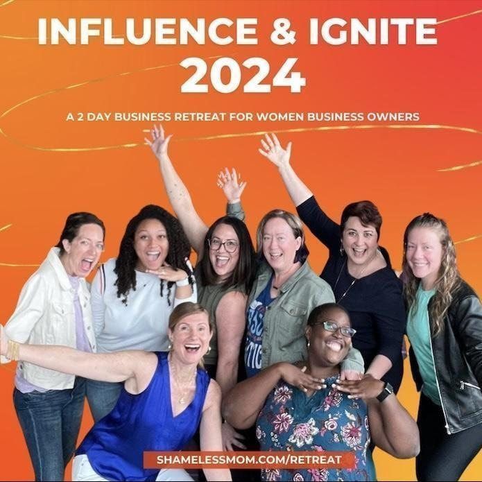 Women business owners smiling with raised arms at “Influence & Ignite 2024” retreat against an orange background