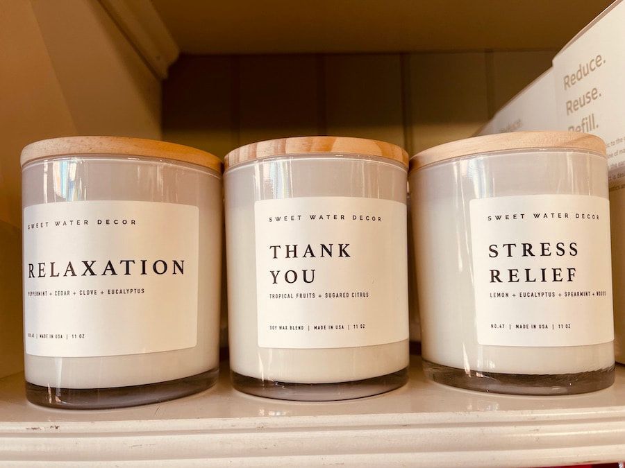 Three rose-gold candles labeled Relaxation, Thank You, and Stress Relief on a shelf