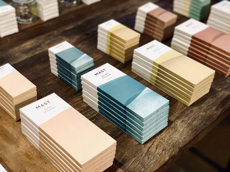 Stacks of pastel and teal color swatch cards arranged on a wooden table.
