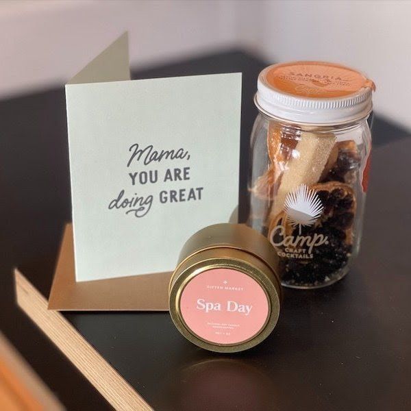 Gift basket with a card reading “Mama, you are doing great,” a spa candle, and a jar of treats.