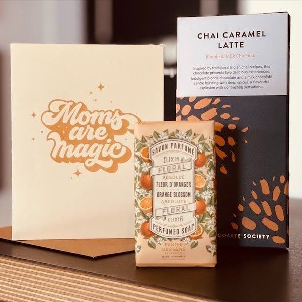 Gift boxes and a coffee bag with a “Mom’s are magic” card and “Chai Caramel Latte” package