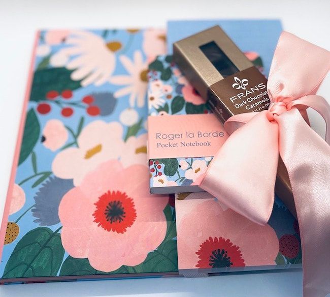 Floral gift boxes tied with a pink ribbon, with a small perfume box on top