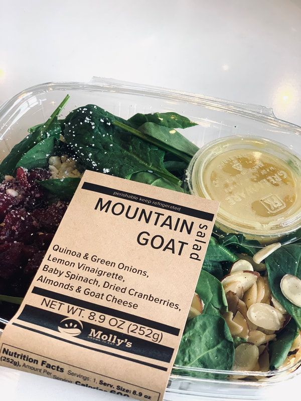 Salad container with goat cheese, greens, candied nuts, and dressing cup, labeled “Mountain Goat”