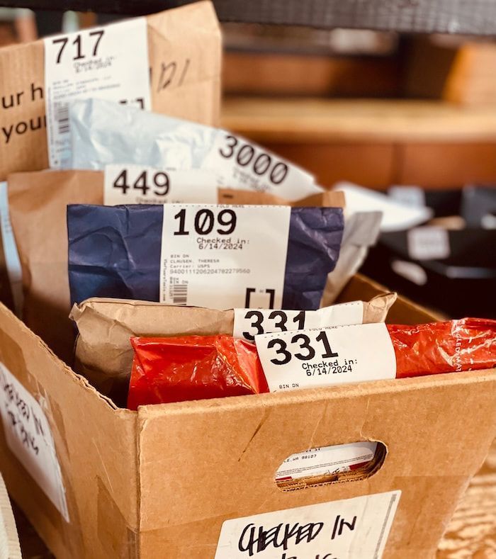 Box of labeled packages in a sorting bin, with tags 717, 449, 3000, 109, and 331.