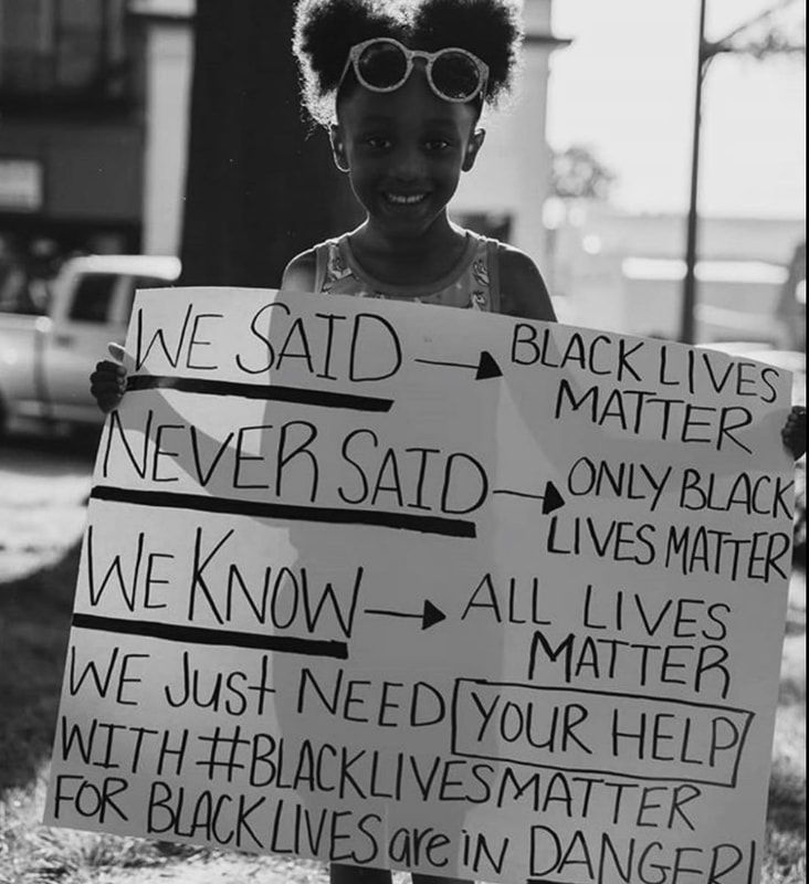 Person holding a sign about Black Lives Matter and All Lives Matter in black-and-white photo