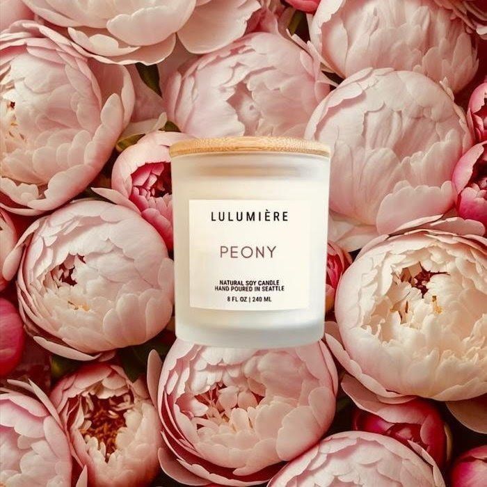LULUMIÈRE Peony candle centered among soft pink peony flowers