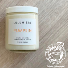 Lulumière Pumpkin soy candle in a cream jar with white lid on a wood surface