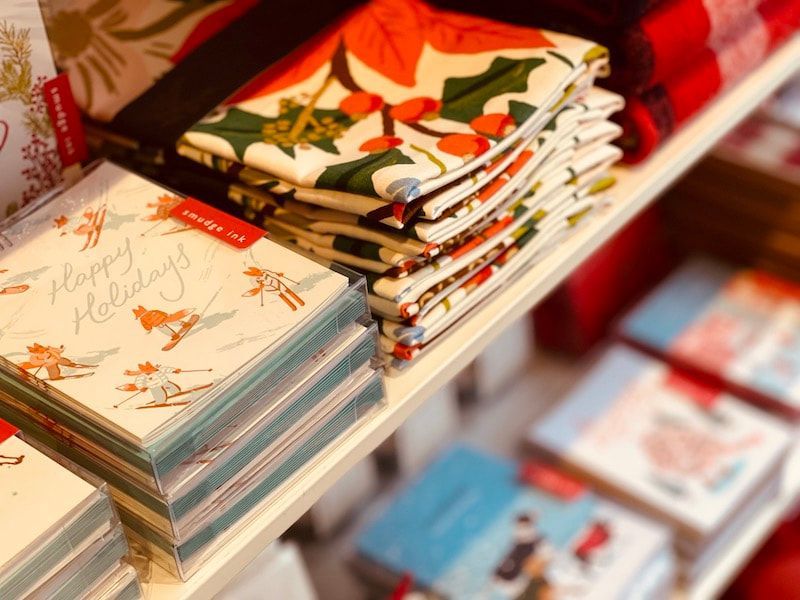 Stacks of colorful folded cards or napkins displayed on a shelf in a shop