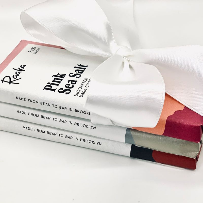 Stacked pink sea salt soap bars tied with a white ribbon on a white background