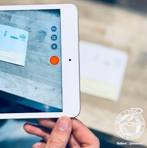 Tablet screen showing a document scanning app on a white device held in hand.